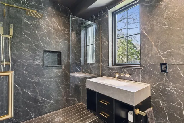 a bathroom with a sink shower and a mirror