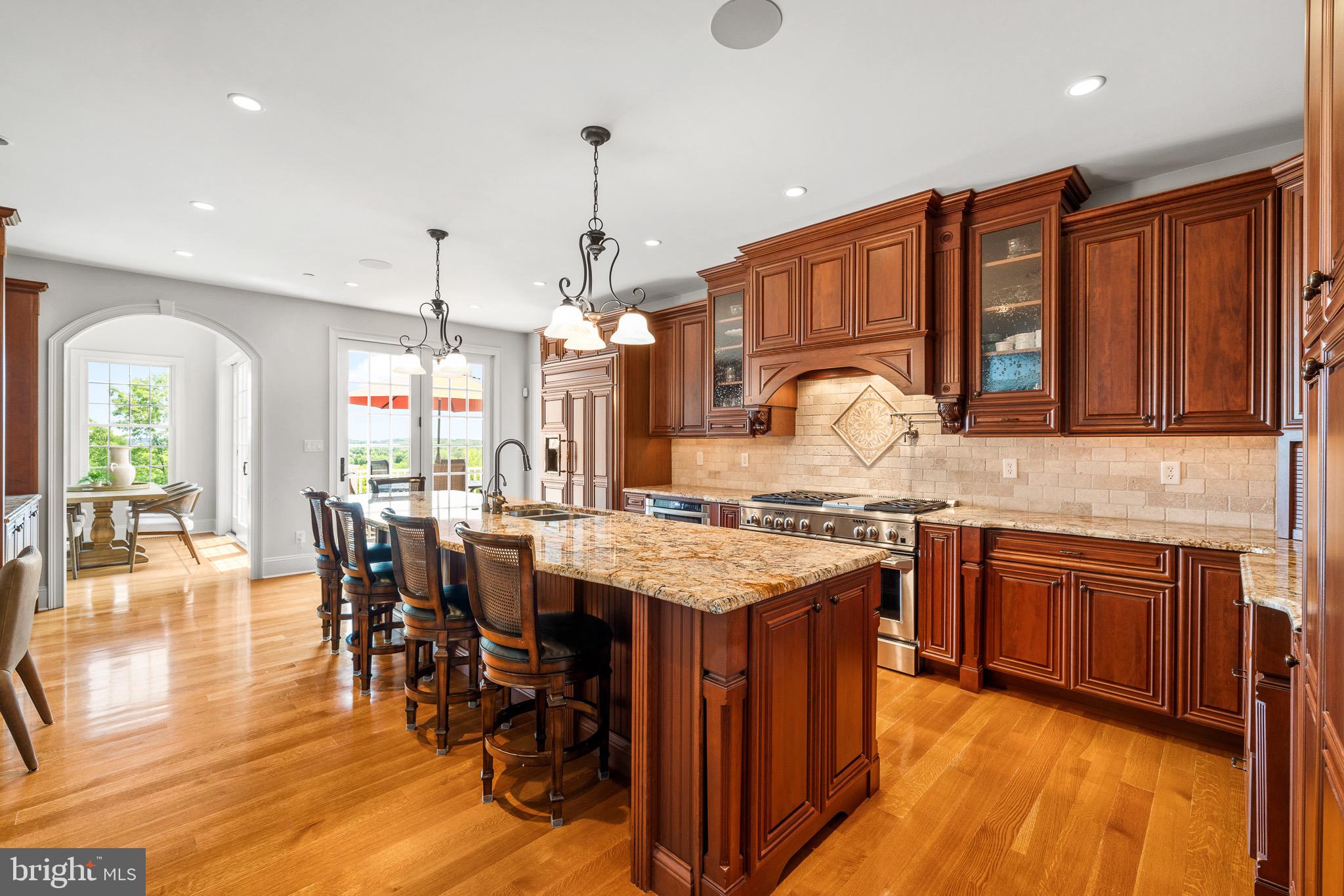 5835 Ridgeview Drive Doylestown, PA 18902 - Photo 25 of 63 a open kitchen with stainless steel appliances granite countertop a stove top oven a sink a dining table and chairs with wooden floor