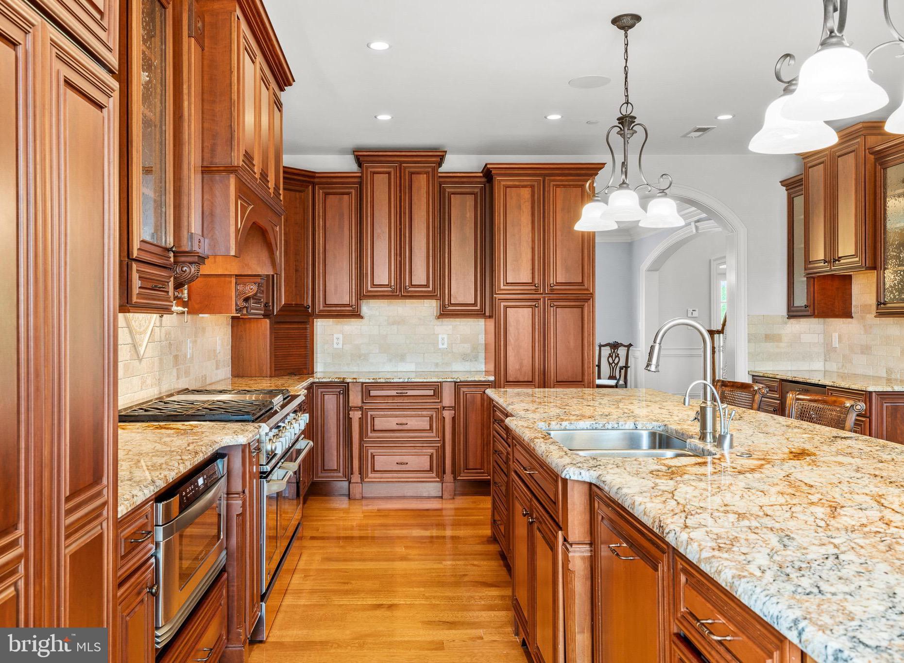 5835 Ridgeview Drive Doylestown, PA 18902 - Photo 27 of 63 a kitchen with stainless steel appliances granite countertop a sink a stove and a wooden floors
