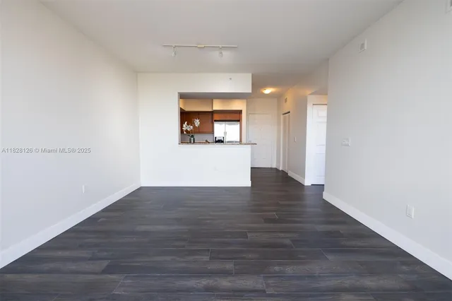 a view of a room with wooden floor and window