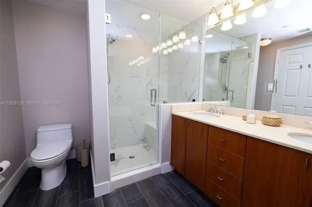 a bathroom with a double vanity sink toilet and shower