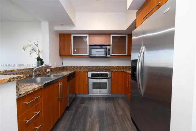 a kitchen with stainless steel appliances granite countertop a stove a sink and a refrigerator