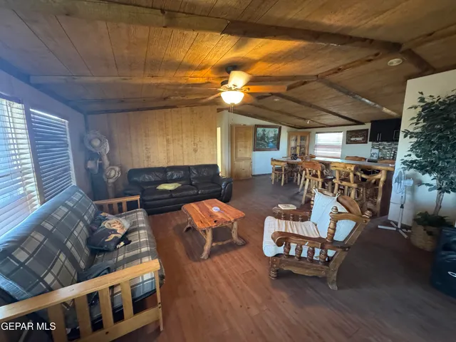 a living room with furniture and a dining table with wooden floor
