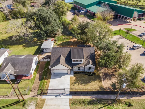 an aerial view of a house with a garden and lake view
