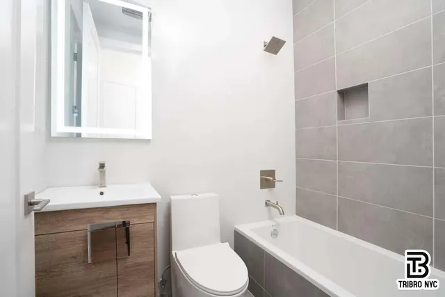 a bathroom with a sink toilet vanity and bathtub