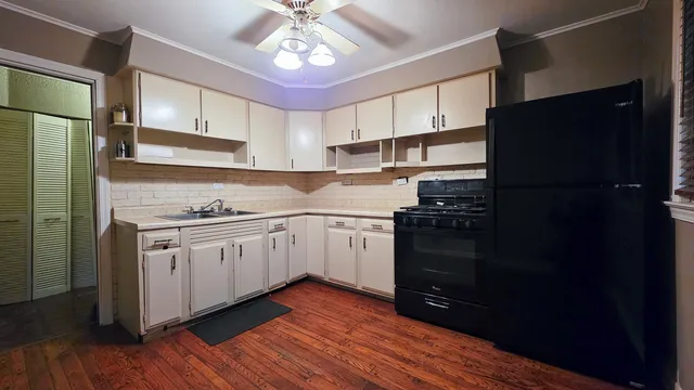 a kitchen with a refrigerator and a stove top oven