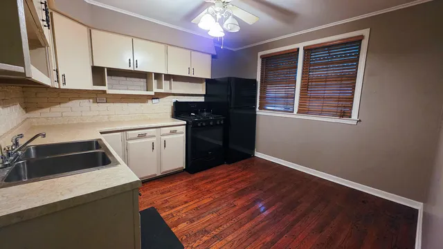 a kitchen that has a microwave oven a sink dishwasher and a refrigerator with wooden floor