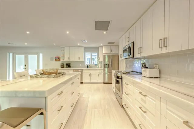 a living room with lots of furniture and view of kitchen