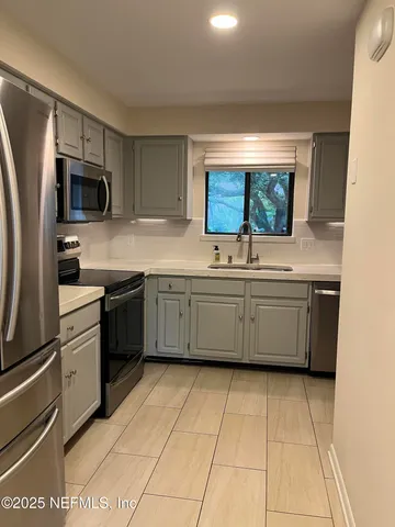 a kitchen with stainless steel appliances a sink and a stove top oven