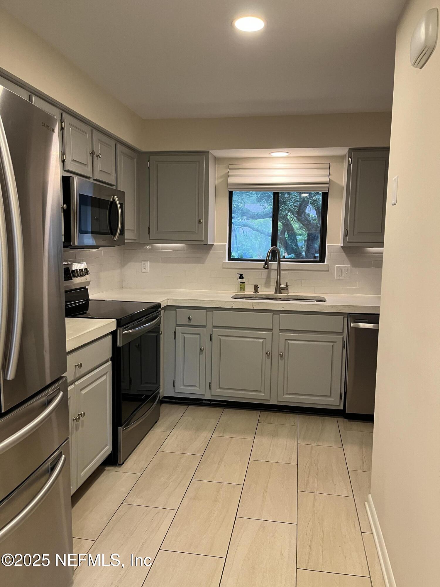 1809 Kings Way Neptune Beach, FL 32266 - Photo 12 of 28 a kitchen with stainless steel appliances a sink and a stove top oven