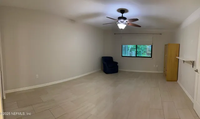 a view of a livingroom with a ceiling fan and window