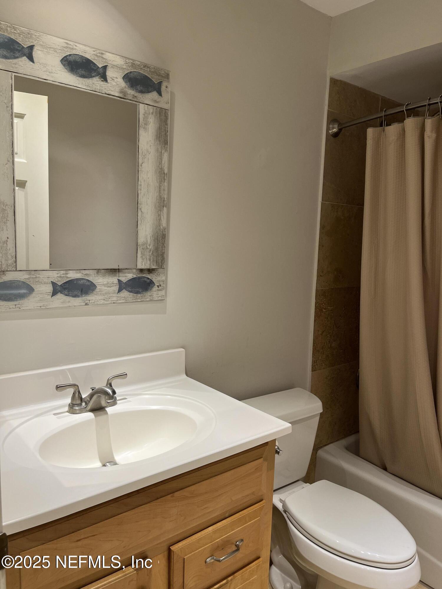 1809 Kings Way Neptune Beach, FL 32266 - Photo 21 of 28 a bathroom with a sink a toilet a mirror and shower curtain