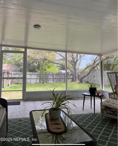 a living room with furniture and a floor to ceiling window