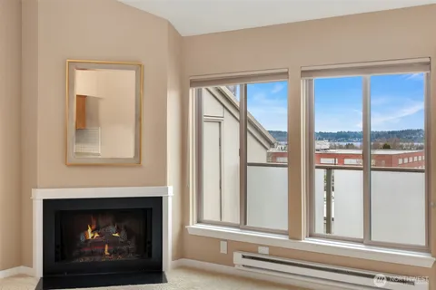 a living room with a fireplace and a floor to ceiling window