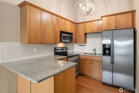 a kitchen with a refrigerator a microwave a sink and cabinets