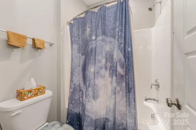 a white toilet sitting next to a shower curtain