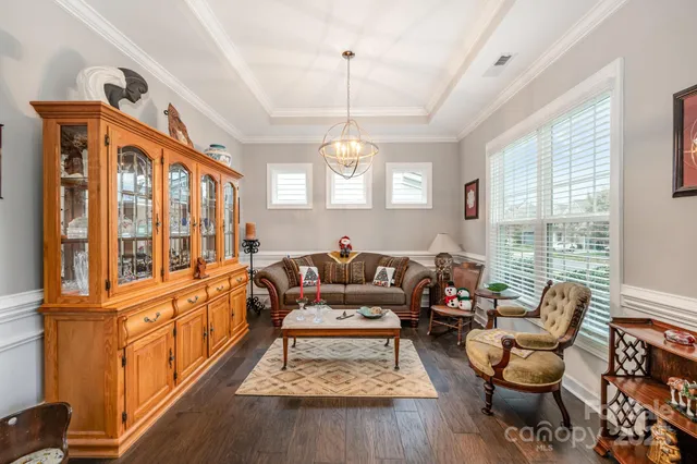 a living room with furniture chandelier and a large window