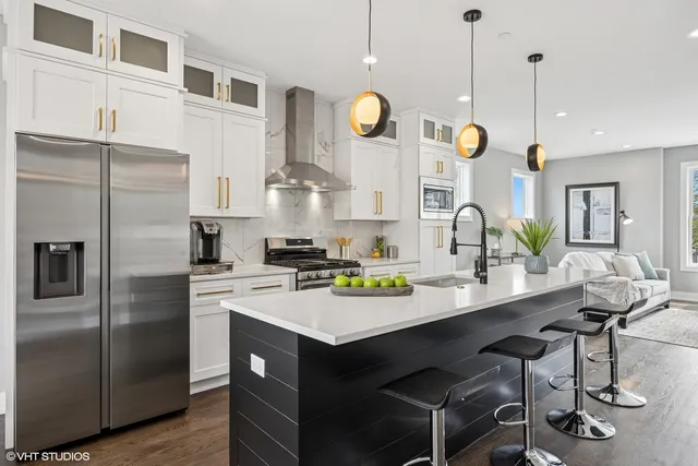a kitchen with a sink stainless steel appliances and chandelier