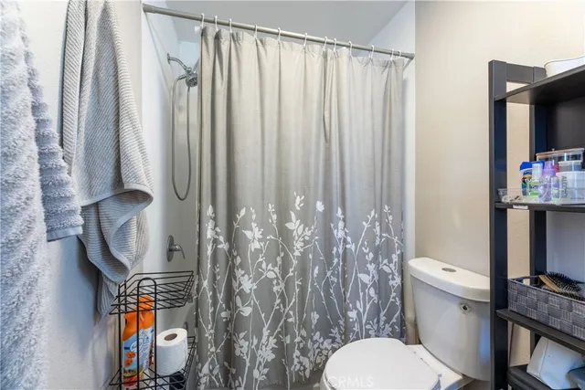a bathroom with a toilet and a shower curtain