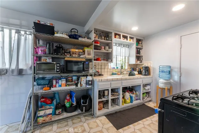 a view of kitchen with stainless steel appliances cabinets and a table
