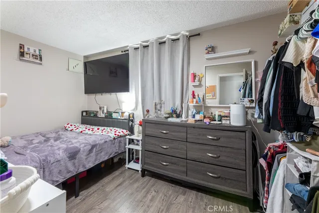 a bedroom with a bed a flat screen tv and dresser