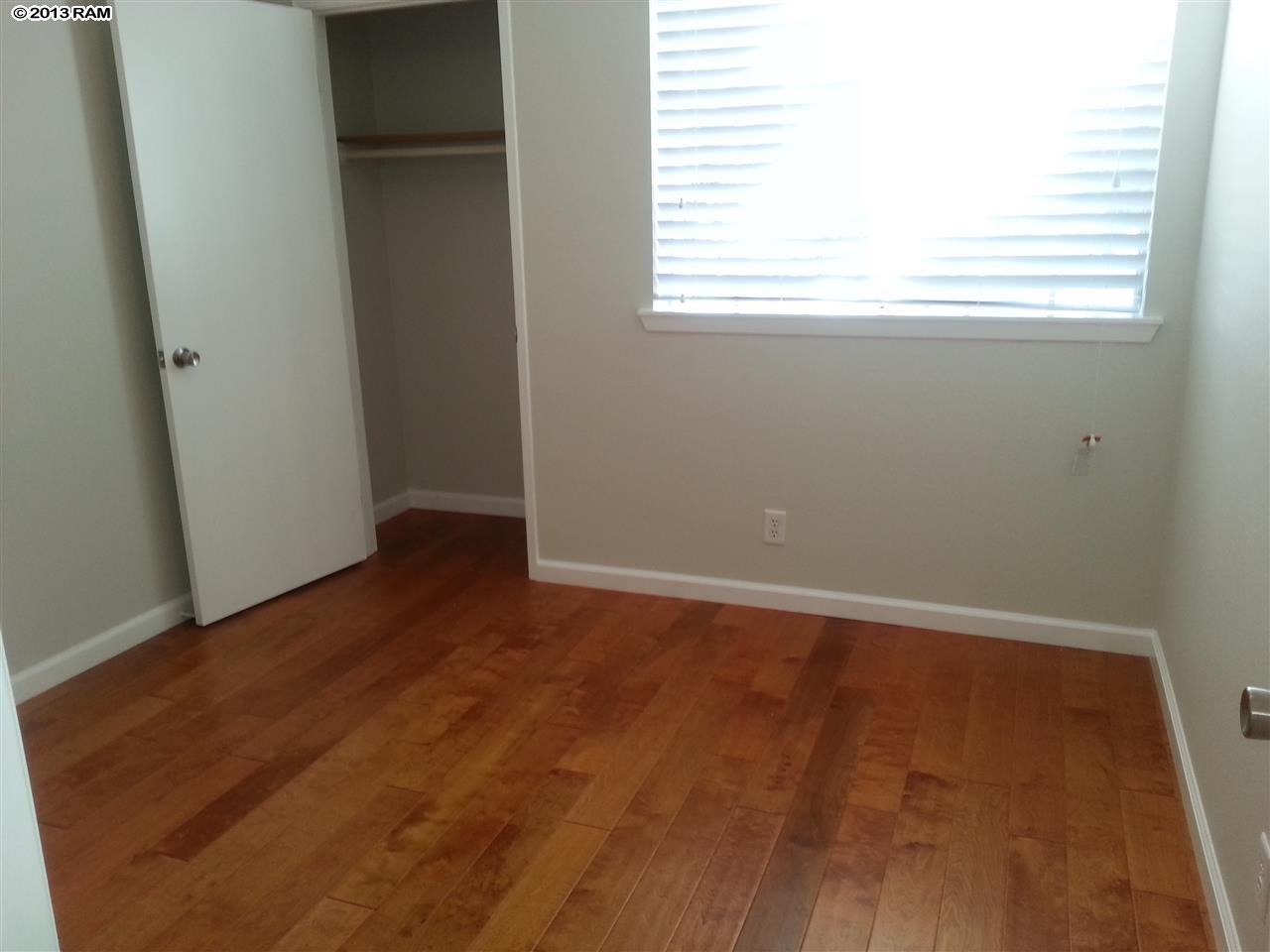 140 Uwapo Road, Unit 9104 Kihei, HI 96753 - Photo 11 of 27 an empty room with wooden floor and windows
