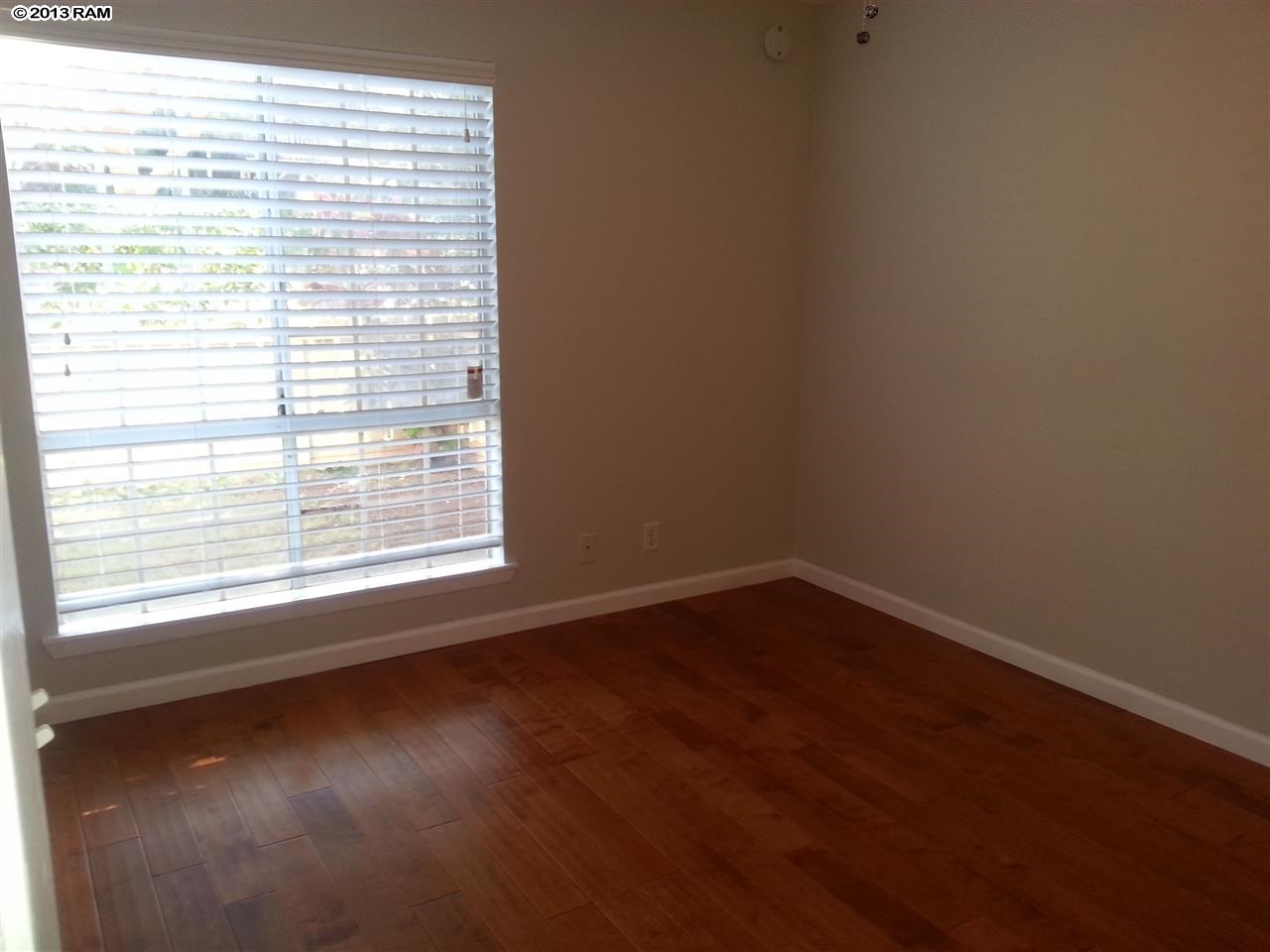 140 Uwapo Road, Unit 9104 Kihei, HI 96753 - Photo 12 of 27 a view of an empty room with wooden floor and a window