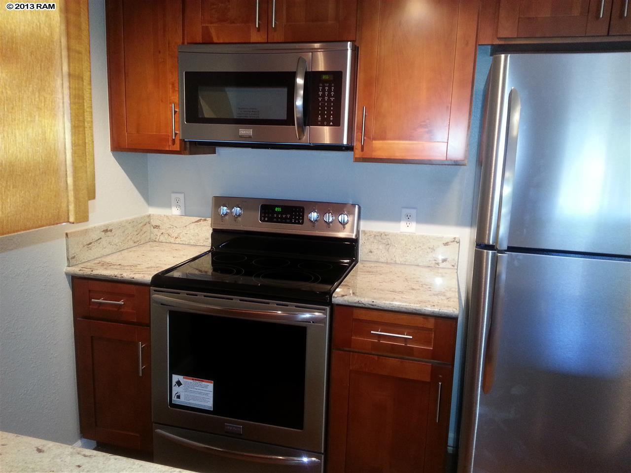 140 Uwapo Road, Unit 9104 Kihei, HI 96753 - Photo 6 of 27 a kitchen with a stove microwave and refrigerator