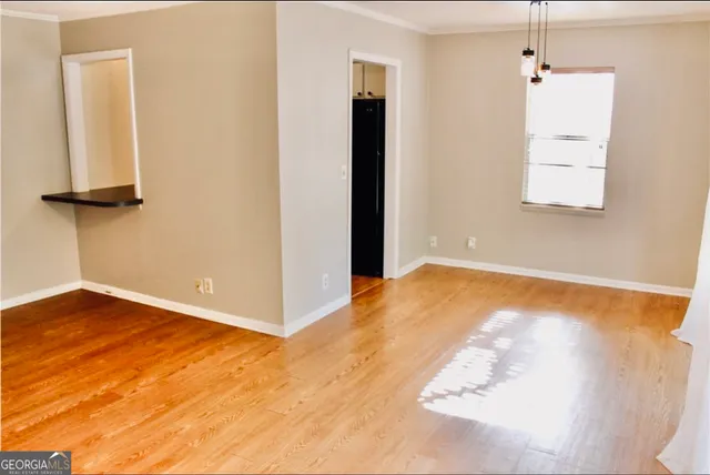 a view of a room with wooden floor and a ceiling fan