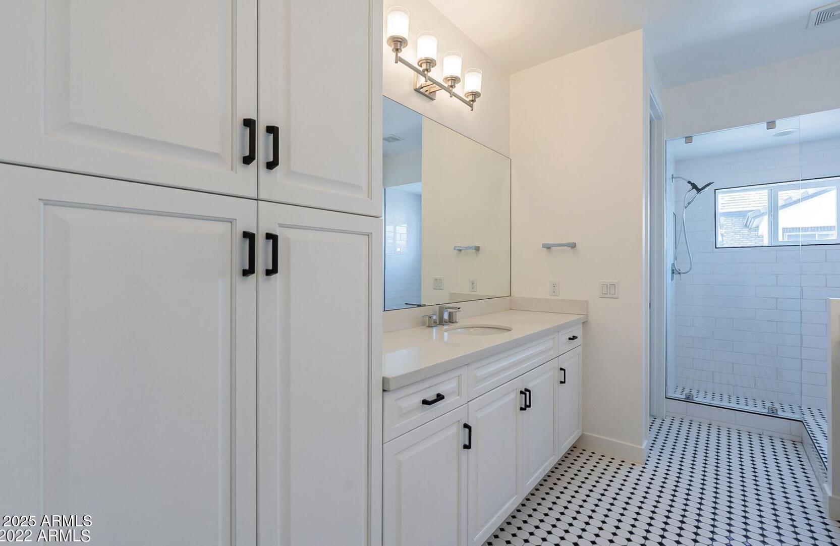 3030 North 38th Street, Unit 113 Phoenix, AZ 85018 - Photo 14 of 22 a spacious bathroom with a double vanity sink a mirror and a shower