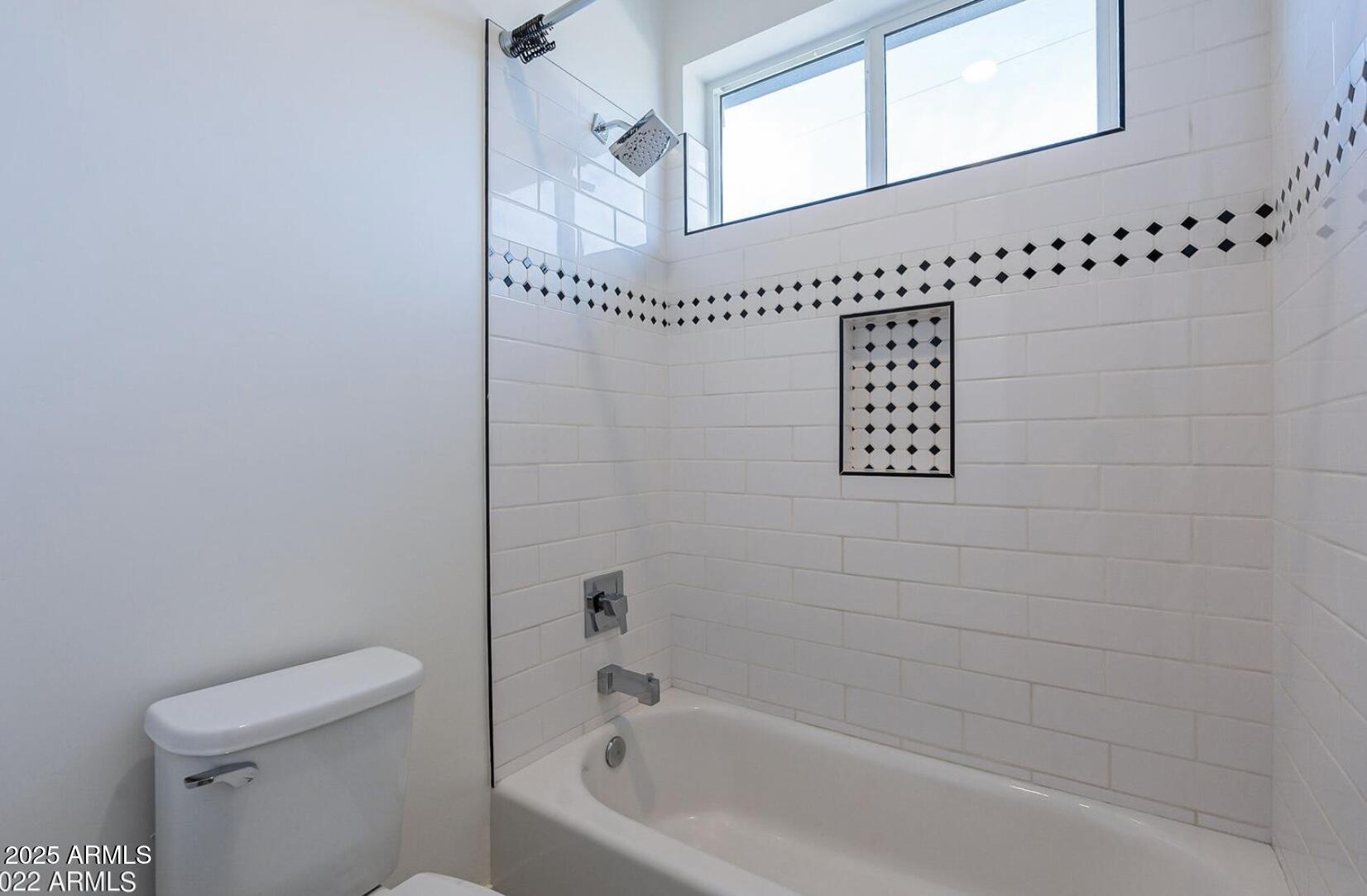 3030 North 38th Street, Unit 113 Phoenix, AZ 85018 - Photo 16 of 22 a bathroom with a bathtub a window and a shower