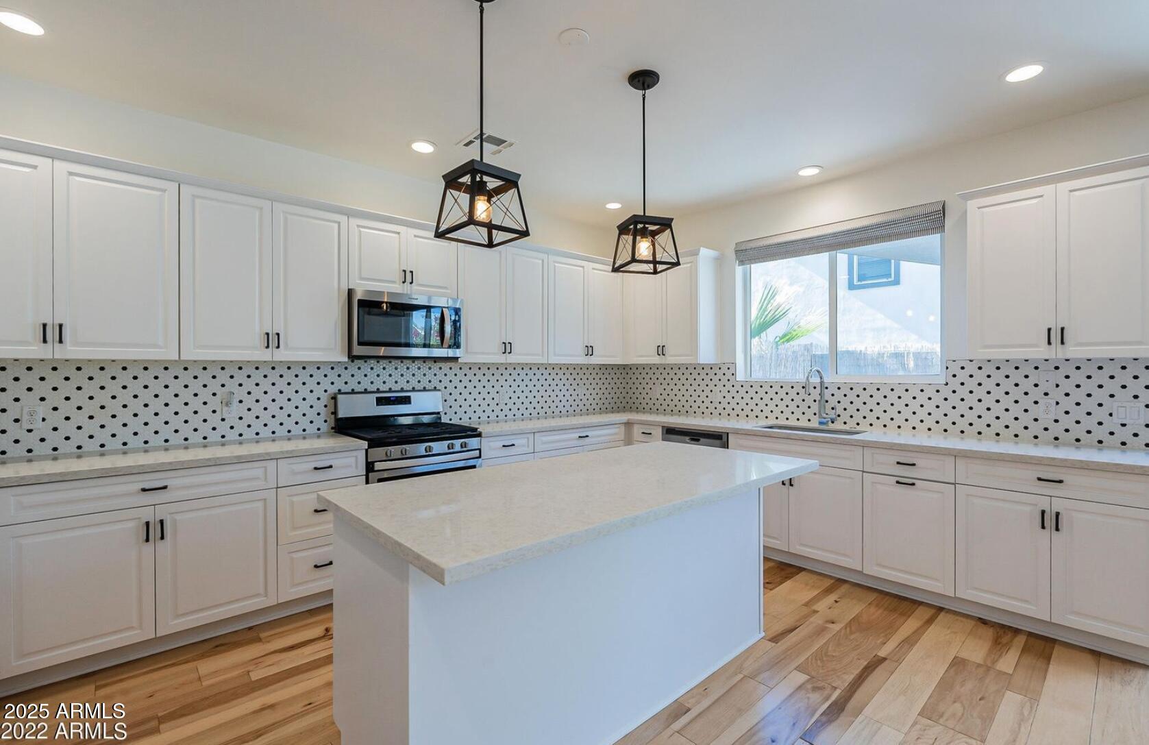3030 North 38th Street, Unit 113 Phoenix, AZ 85018 - Photo 2 of 22 a kitchen with stainless steel appliances granite countertop a sink a stove and white cabinets