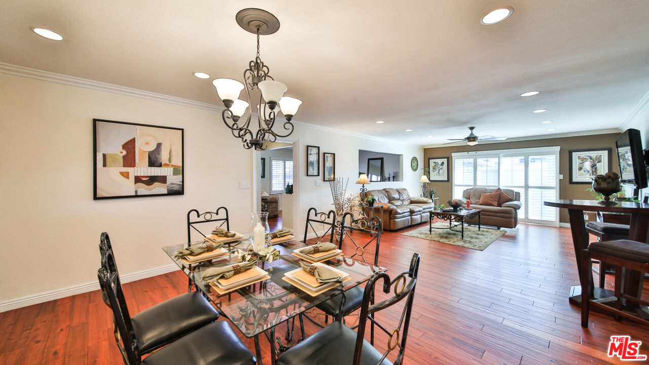 16953 Roa Drive Carson, CA 90746 - Photo 17 of 48 a dining room with wooden floor a chandelier a wooden table and chairs