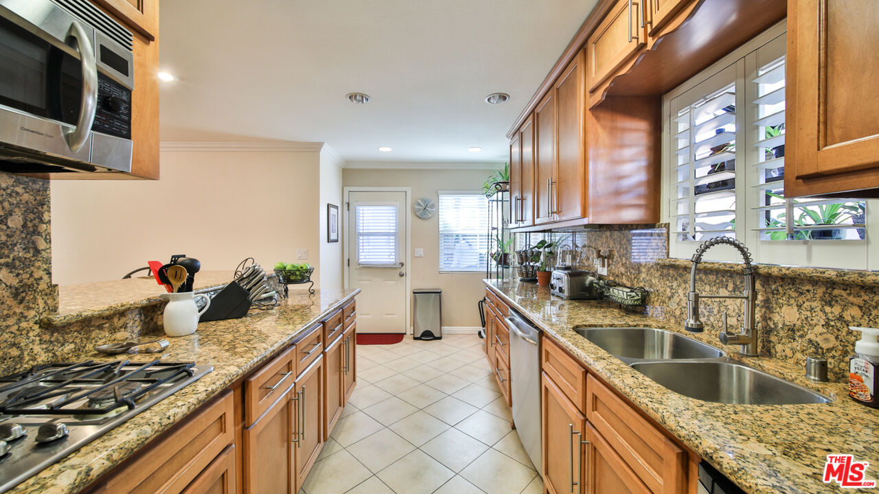 16953 Roa Drive Carson, CA 90746 - Photo 22 of 48 a kitchen with stainless steel appliances granite countertop a sink stove and refrigerator