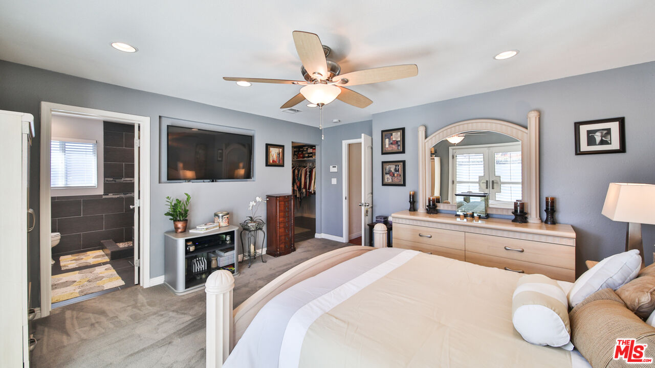 16953 Roa Drive Carson, CA 90746 - Photo 35 of 48 a bedroom with a bed and a large mirror with a flat tv screen