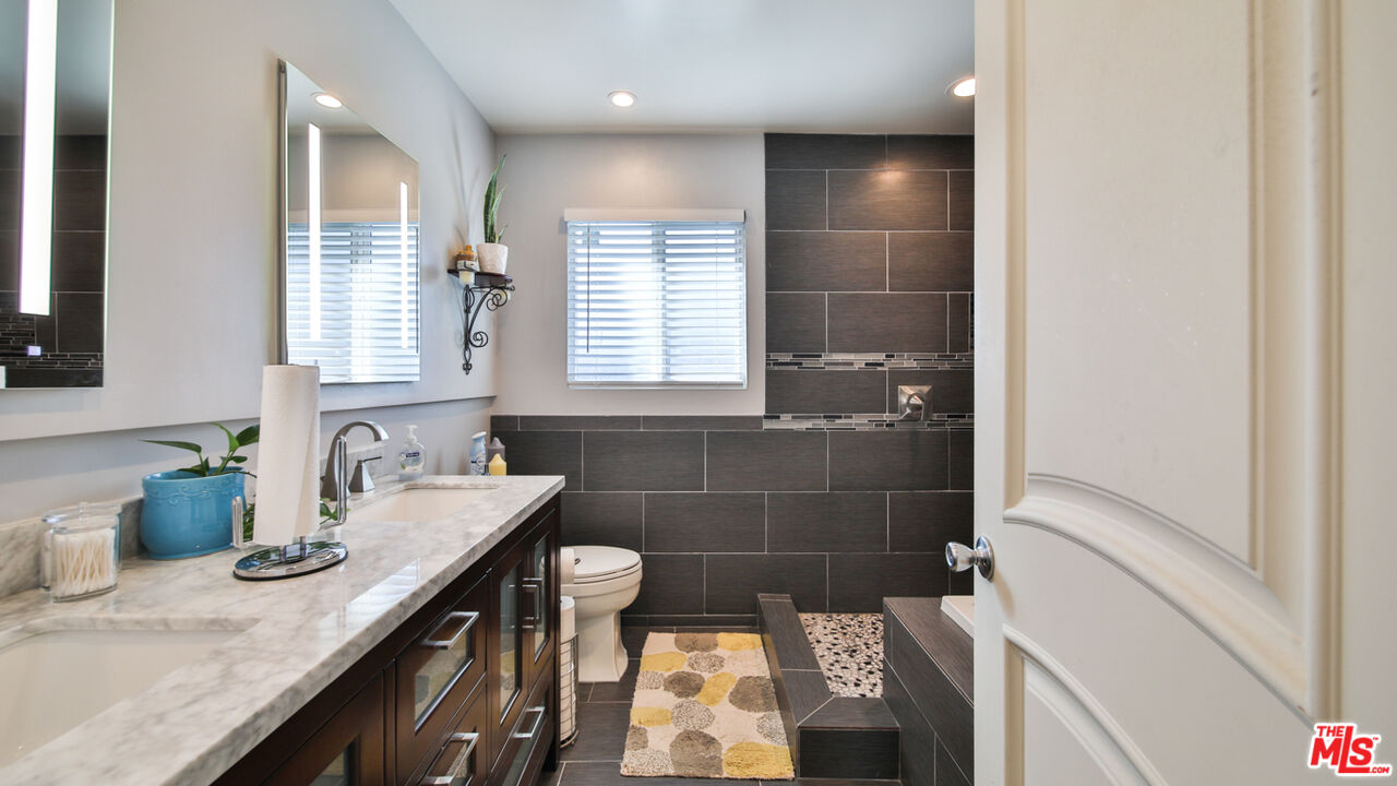 16953 Roa Drive Carson, CA 90746 - Photo 38 of 48 a bathroom with a granite countertop sink a mirror and shower