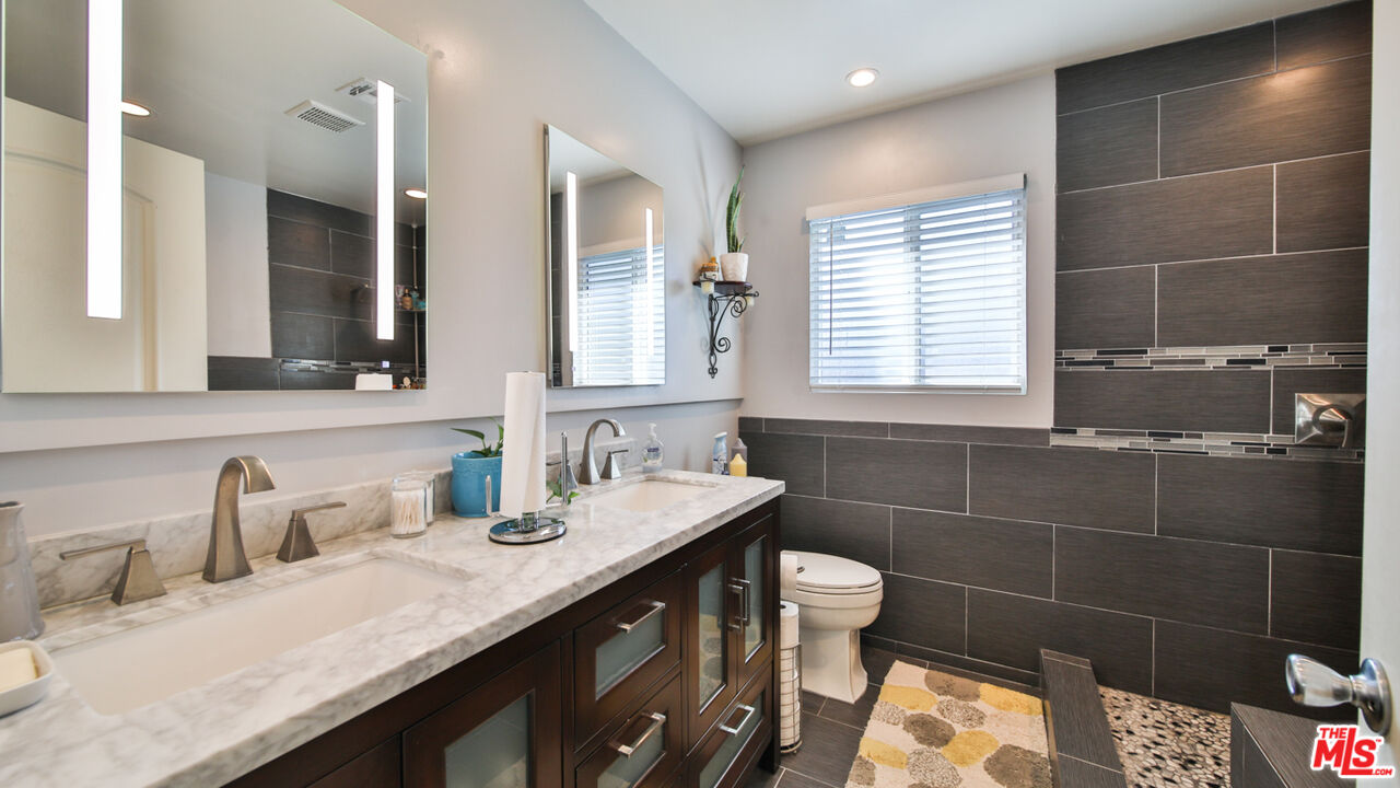 16953 Roa Drive Carson, CA 90746 - Photo 39 of 48 a bathroom with a granite countertop sink a toilet and a mirror