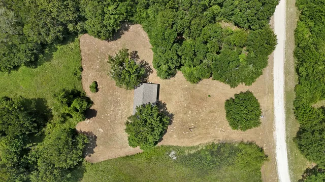 an aerial view of a house with a yard and lake view
