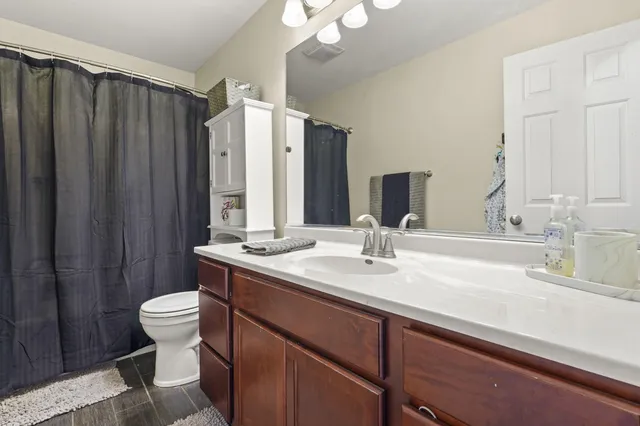 a bathroom with a double vanity sink toilet and a mirror