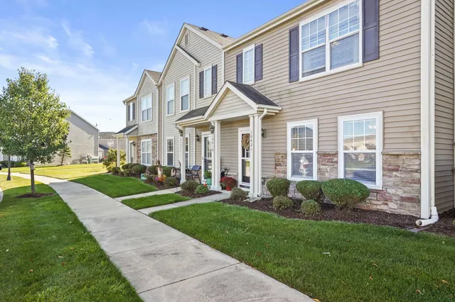 a front view of a house with yard and green space