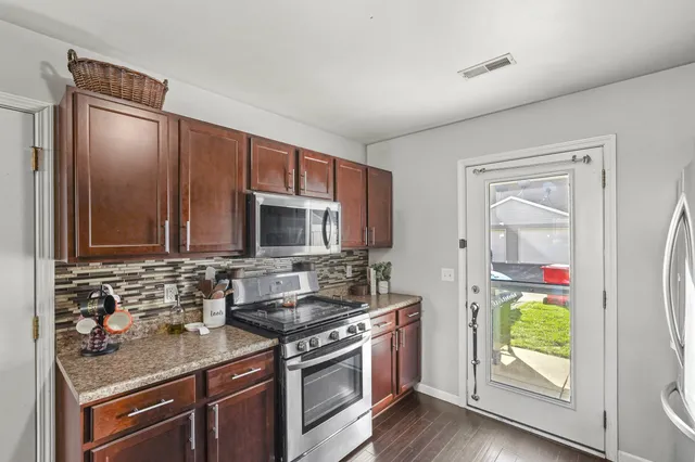 a kitchen with stainless steel appliances granite countertop a stove a sink and a microwave