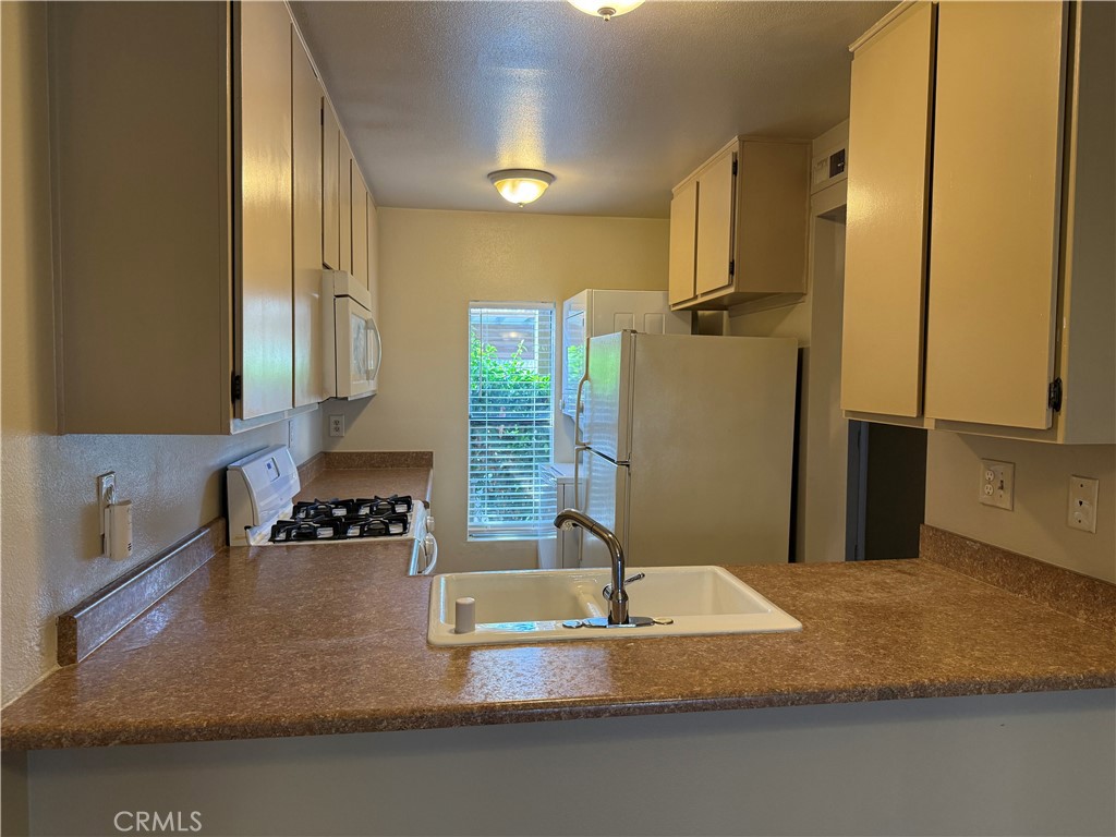 122 Tangelo Irvine, CA 92618 - Photo 19 of 34 a kitchen with kitchen island a counter top space a sink a refrigerator and a stove