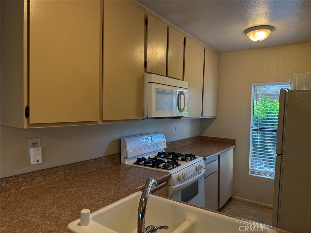 122 Tangelo Irvine, CA 92618 - Photo 7 of 34 a kitchen with stainless steel appliances granite countertop a sink stove and refrigerator