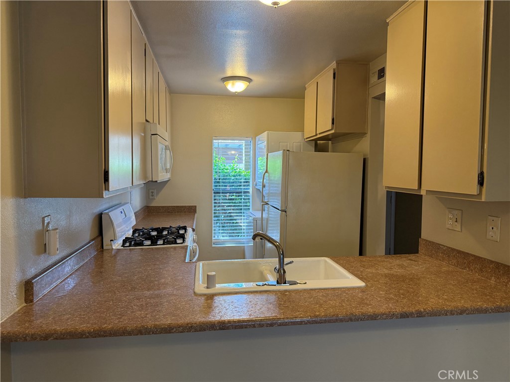 122 Tangelo Irvine, CA 92618 - Photo 9 of 34 a kitchen with kitchen island granite countertop a sink a stove and a refrigerator