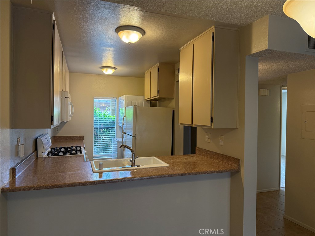 122 Tangelo Irvine, CA 92618 - Photo 10 of 34 a kitchen with a sink and a refrigerator