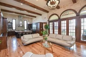 a living room with furniture a large window and a chandelier
