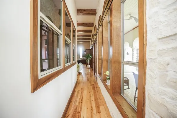 a view of a hallway with wooden floor and staircase