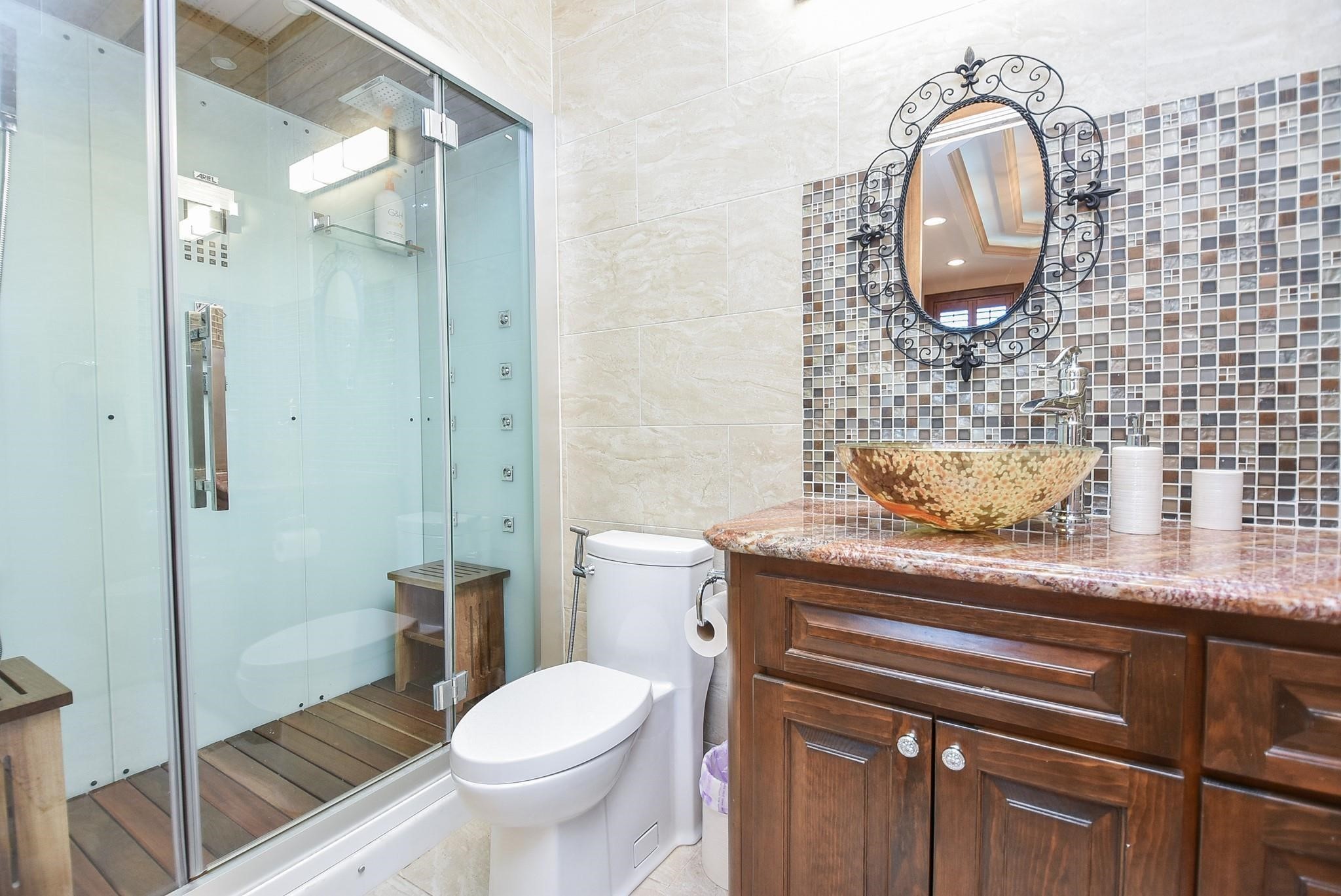 825 Grubbs Road Sealy, TX 77474 - Photo 22 of 49 a bathroom with a granite countertop toilet a sink and a mirror