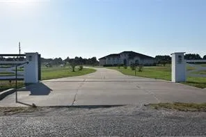 a view of a road with a large barn in the background