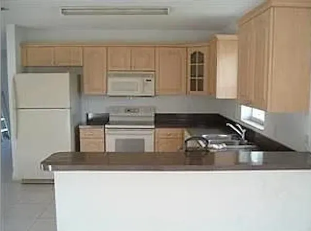 a kitchen with kitchen island a sink stove and refrigerator